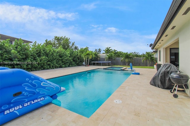 view of swimming pool featuring an in ground hot tub and a patio