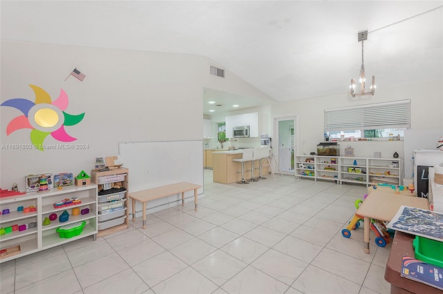 recreation room featuring lofted ceiling, light tile patterned flooring, and an inviting chandelier