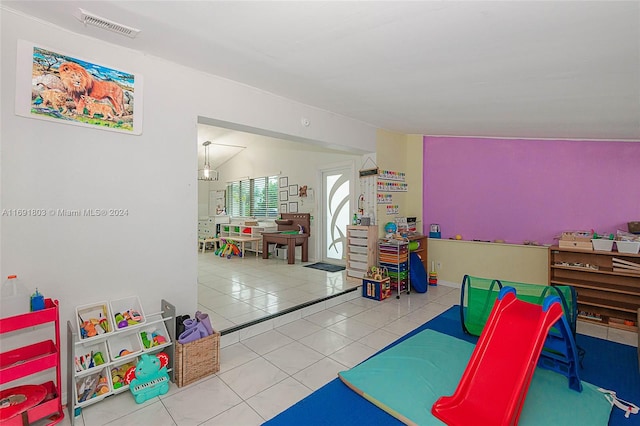 game room featuring light tile patterned floors and vaulted ceiling