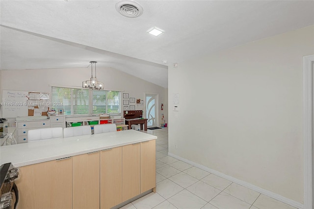 kitchen with light tile patterned floors, light brown cabinetry, pendant lighting, a chandelier, and lofted ceiling