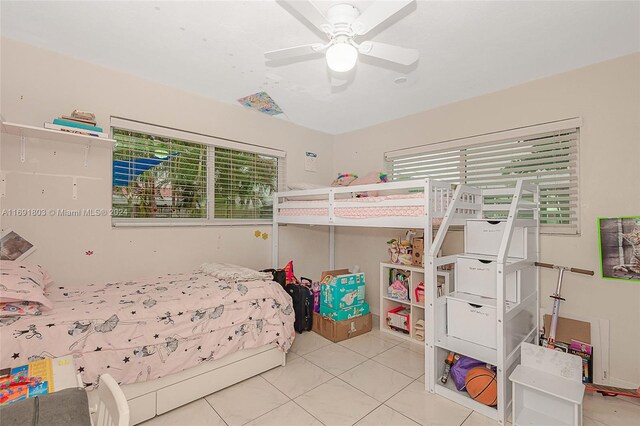 tiled bedroom featuring ceiling fan and multiple windows