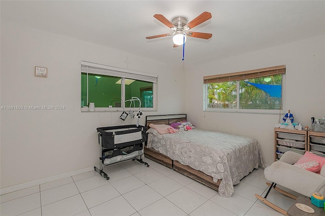 tiled bedroom featuring ceiling fan