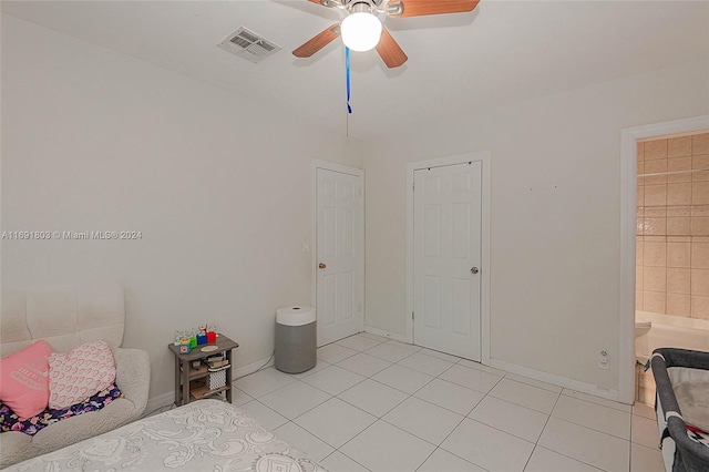 unfurnished bedroom with ceiling fan, connected bathroom, and light tile patterned floors