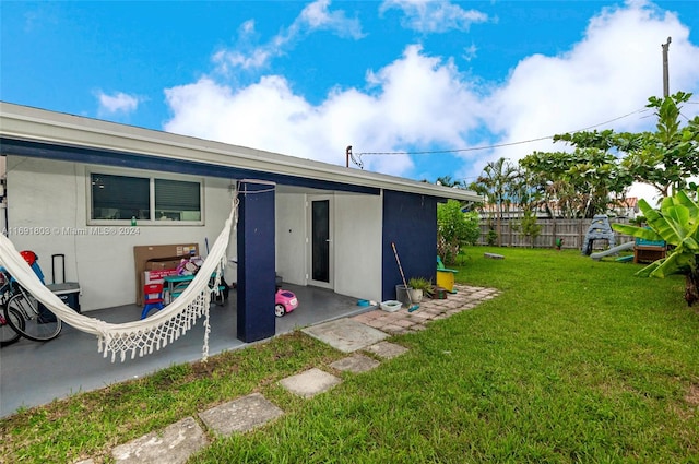 rear view of property with a lawn and a patio