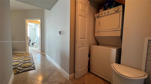 clothes washing area with stacked washer and clothes dryer