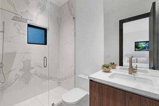 bathroom featuring toilet, vanity, and a shower with door