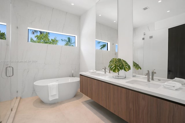 bathroom featuring tile walls, vanity, and independent shower and bath