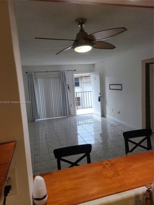 dining room with tile patterned flooring, a textured ceiling, and ceiling fan