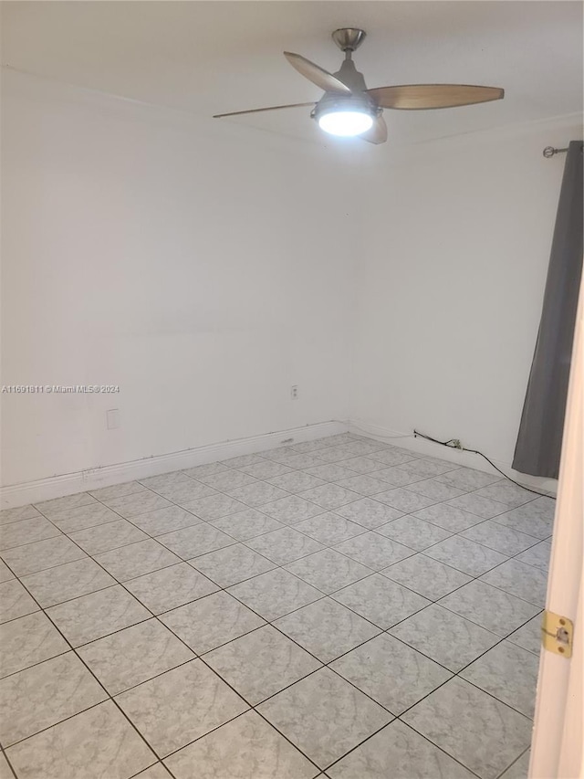 tiled empty room featuring ceiling fan