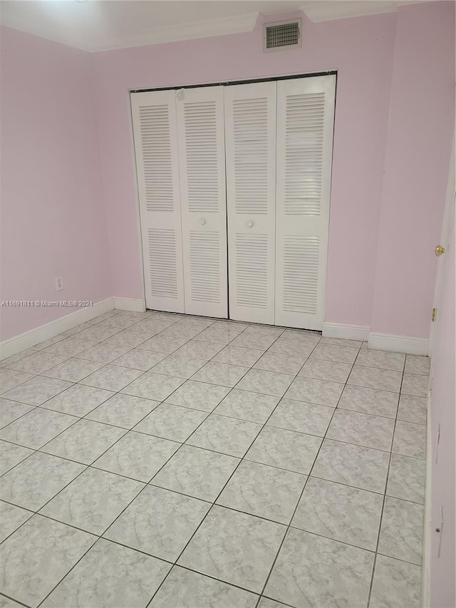 unfurnished bedroom featuring light tile patterned floors and a closet