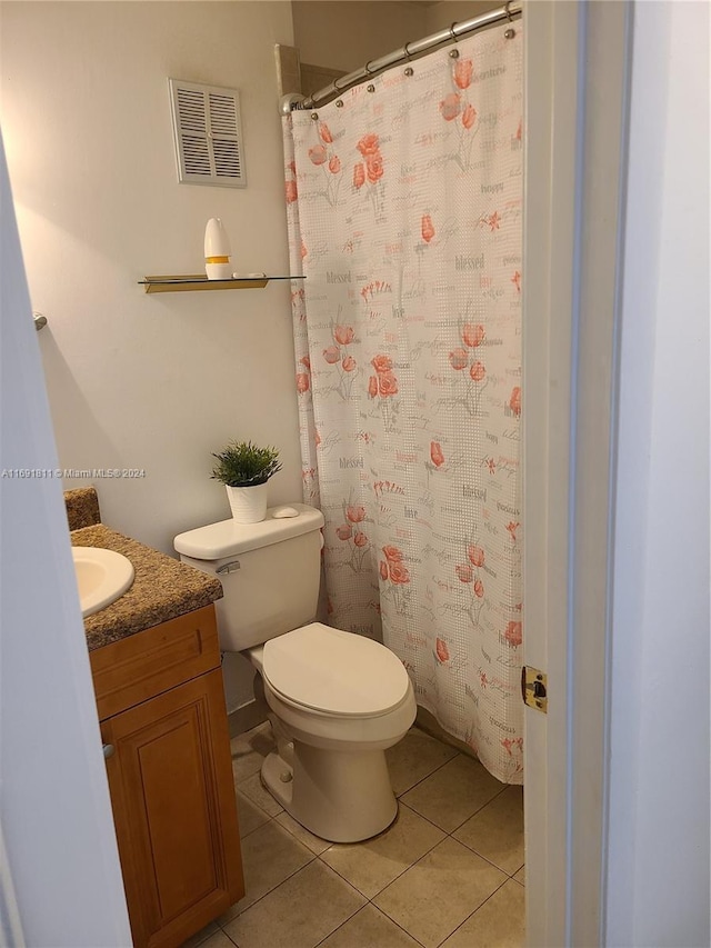 bathroom featuring tile patterned flooring, vanity, and toilet