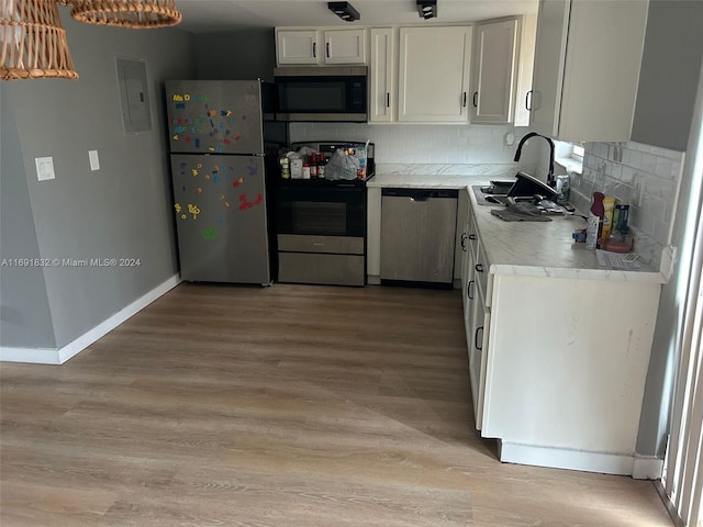 kitchen with light wood-type flooring, white cabinets, decorative backsplash, and stainless steel appliances