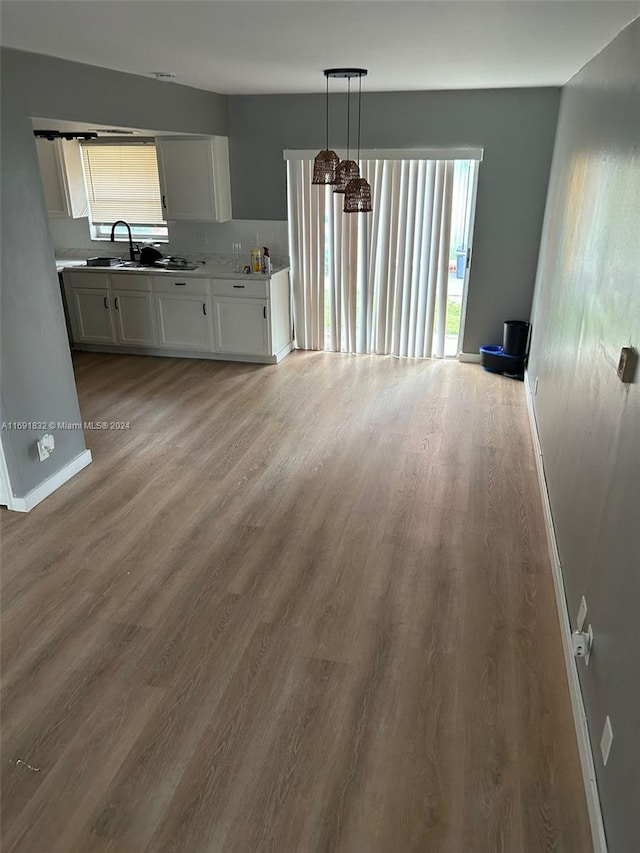 unfurnished living room with wood-type flooring and sink