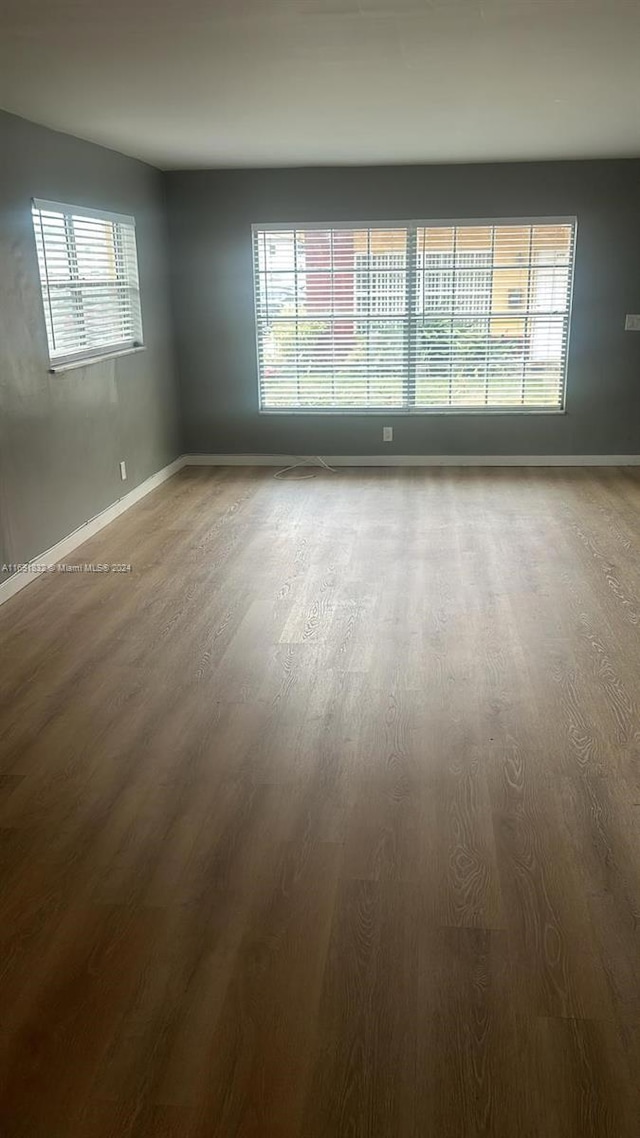 unfurnished room featuring hardwood / wood-style floors and plenty of natural light