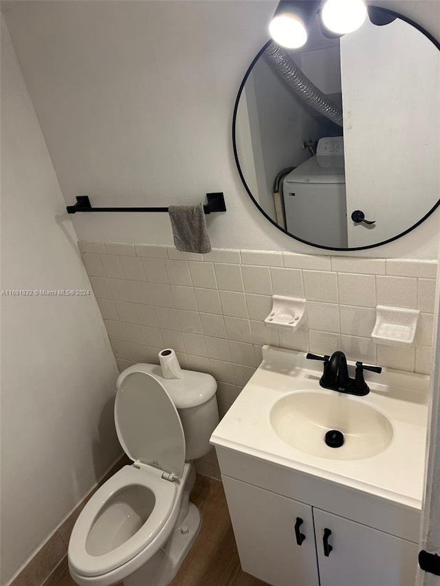 bathroom featuring vanity, toilet, and tile walls