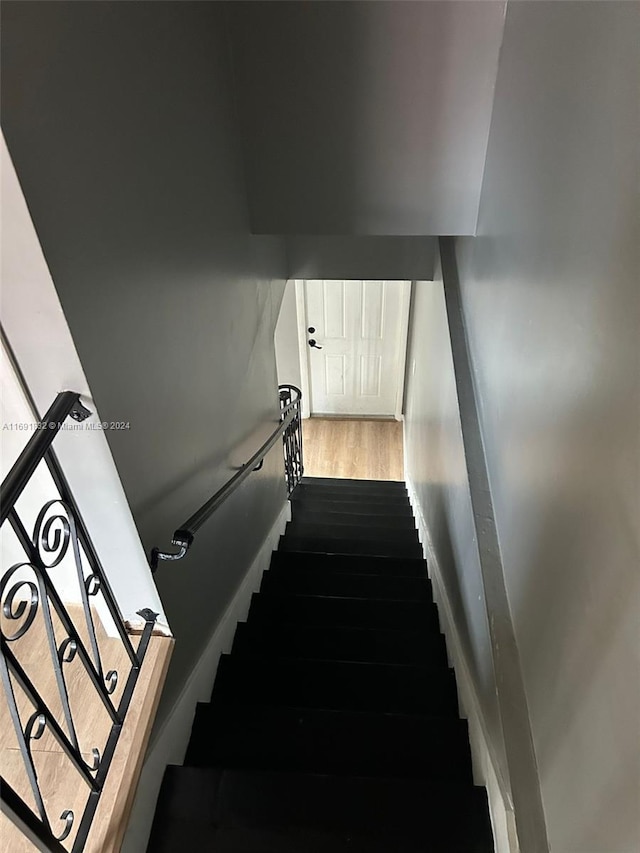 staircase with hardwood / wood-style floors