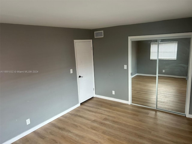 unfurnished bedroom with hardwood / wood-style floors and a closet