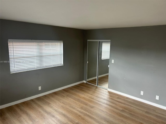 unfurnished bedroom featuring a closet and light wood-type flooring