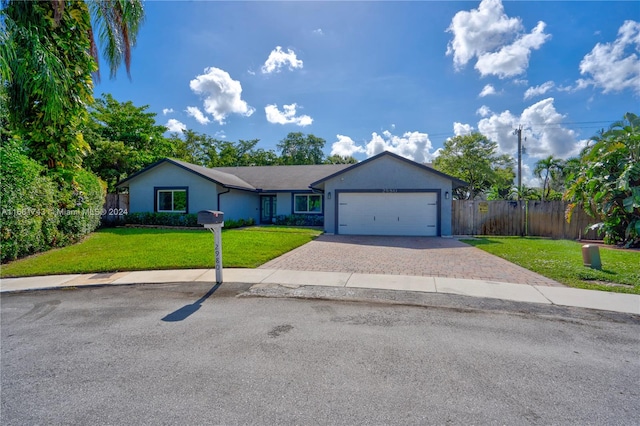 ranch-style house with a garage and a front lawn