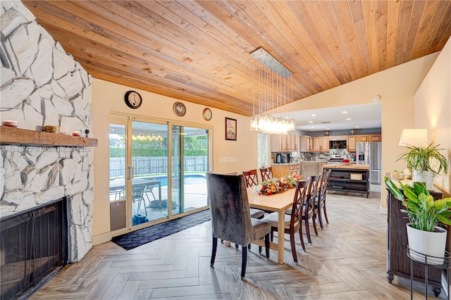 dining space with wooden ceiling, a stone fireplace, light parquet floors, and lofted ceiling