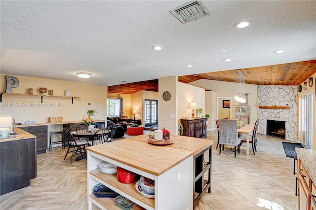 dining space featuring light parquet floors, a textured ceiling, and a fireplace