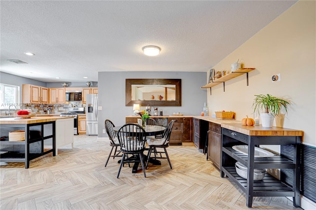 dining room with a textured ceiling and light parquet floors