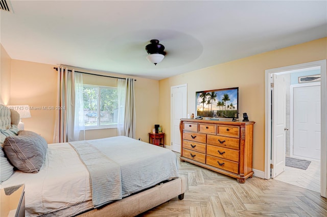 bedroom with ensuite bathroom, ceiling fan, and light parquet floors