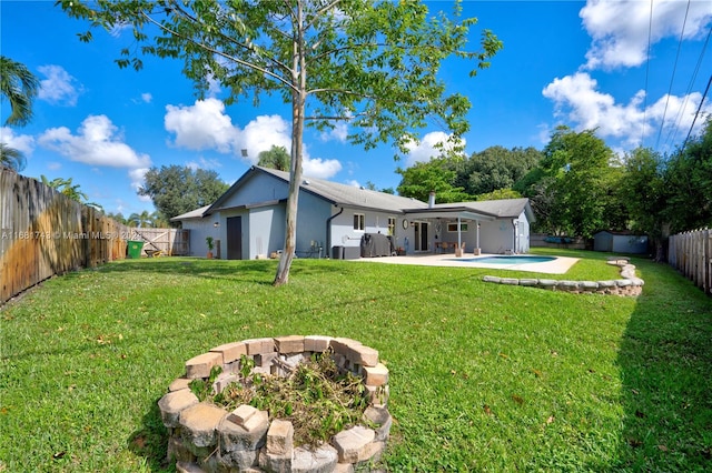 back of property with a patio area, a yard, and a storage shed