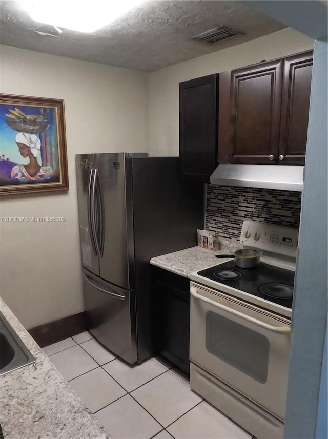 kitchen featuring tasteful backsplash, extractor fan, dark brown cabinets, light tile patterned floors, and electric range