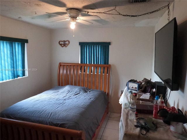 tiled bedroom featuring ceiling fan and a textured ceiling