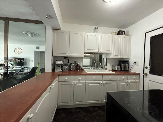 1395 NE 167th St Unit 315, Miami, FL 33162 - kitchen with a sink, dark countertops, and white cabinetry