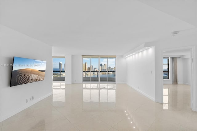 unfurnished living room featuring a wealth of natural light, light tile patterned floors, and expansive windows