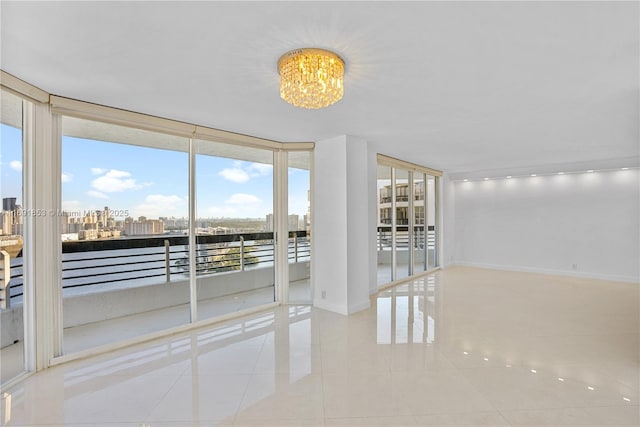 spare room with expansive windows, light tile patterned floors, and an inviting chandelier