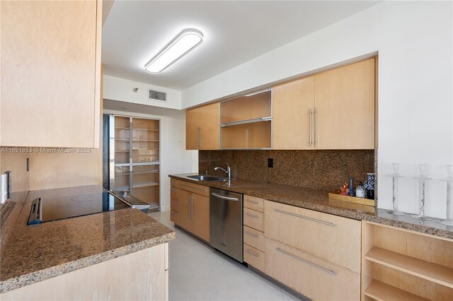 kitchen with light brown cabinets, sink, stainless steel dishwasher, dark stone counters, and black electric stovetop