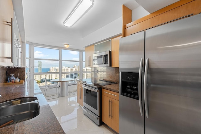 kitchen featuring backsplash, light tile patterned flooring, dark stone counters, and stainless steel appliances