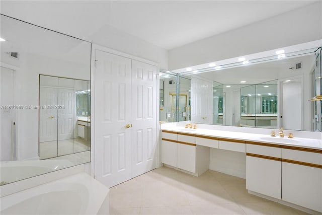 bathroom with tile patterned flooring, vanity, and a tub