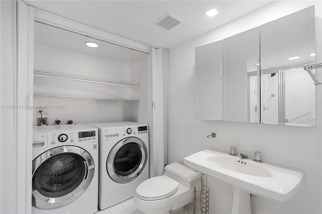 clothes washing area featuring separate washer and dryer, sink, and light tile patterned floors