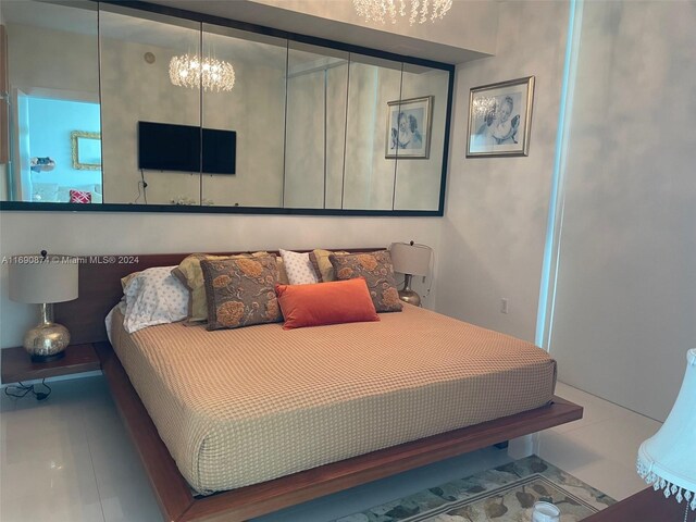 bedroom featuring tile patterned flooring and a notable chandelier