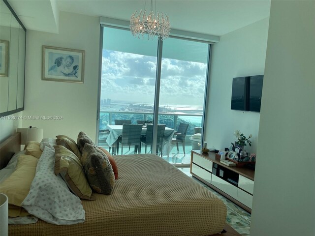 bedroom featuring access to outside, expansive windows, and a chandelier