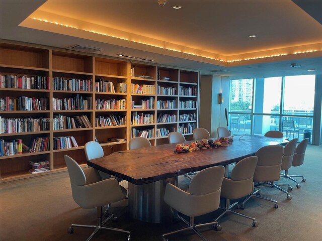 home office with a tray ceiling and carpet flooring