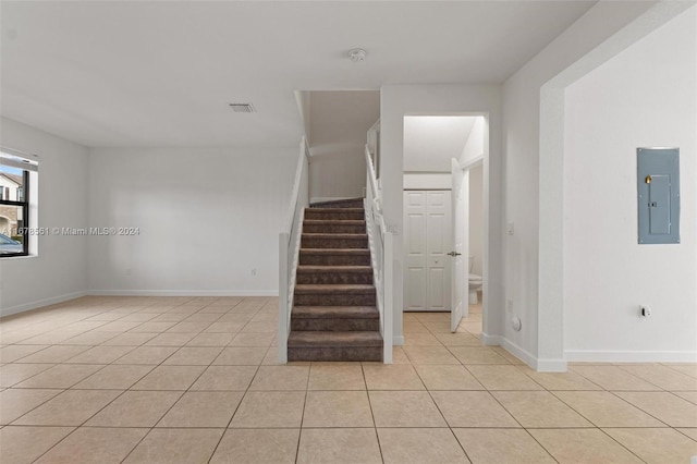 stairway with electric panel and tile patterned floors