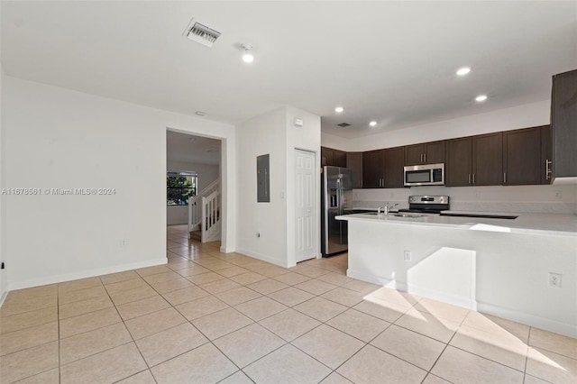 kitchen featuring dark brown cabinets, electric panel, stainless steel appliances, and light tile patterned floors