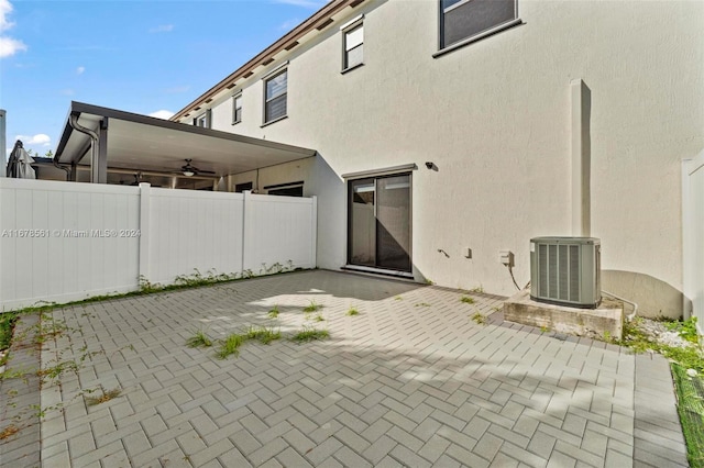 back of property featuring central air condition unit, ceiling fan, and a patio