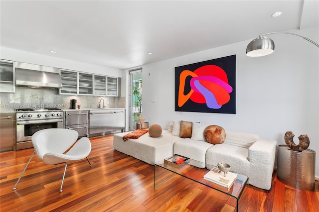 living room with hardwood / wood-style floors and sink