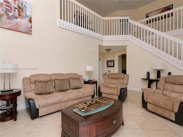 tiled living room featuring a towering ceiling