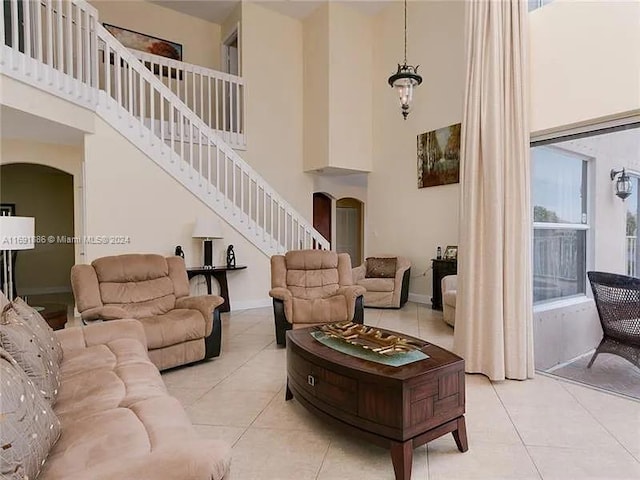 tiled living room featuring a towering ceiling