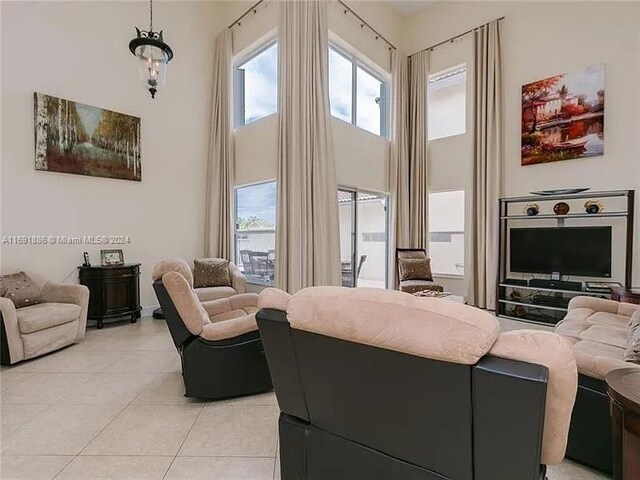 living room featuring a towering ceiling and light tile patterned floors