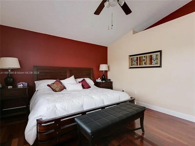 bedroom featuring dark hardwood / wood-style flooring, vaulted ceiling, and ceiling fan