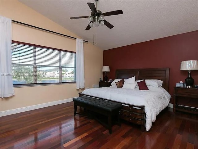 bedroom featuring ceiling fan, vaulted ceiling, dark hardwood / wood-style floors, and a textured ceiling