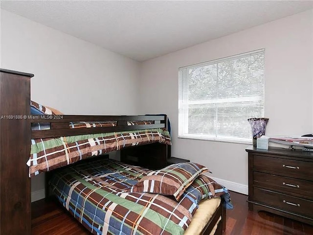 bedroom with dark hardwood / wood-style flooring